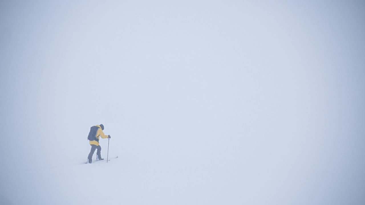 活跃的运动员在极端天气的冬天在劈开板滑雪旅行视频素材