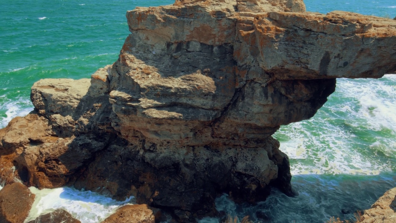 海浪在岩石上荡漾——在刮风的白天，从悬崖顶上看到的海景视频素材