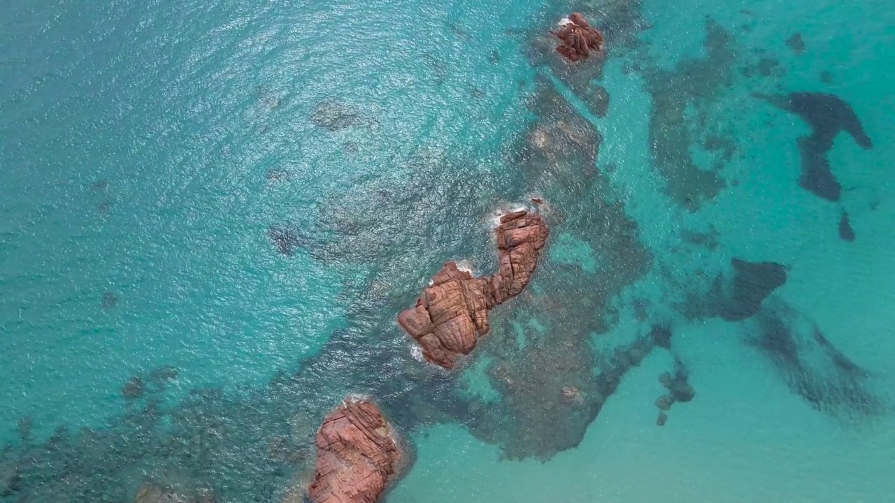 意大利撒丁岛Cea海滩附近清澈海水中的岩层航拍照片视频素材