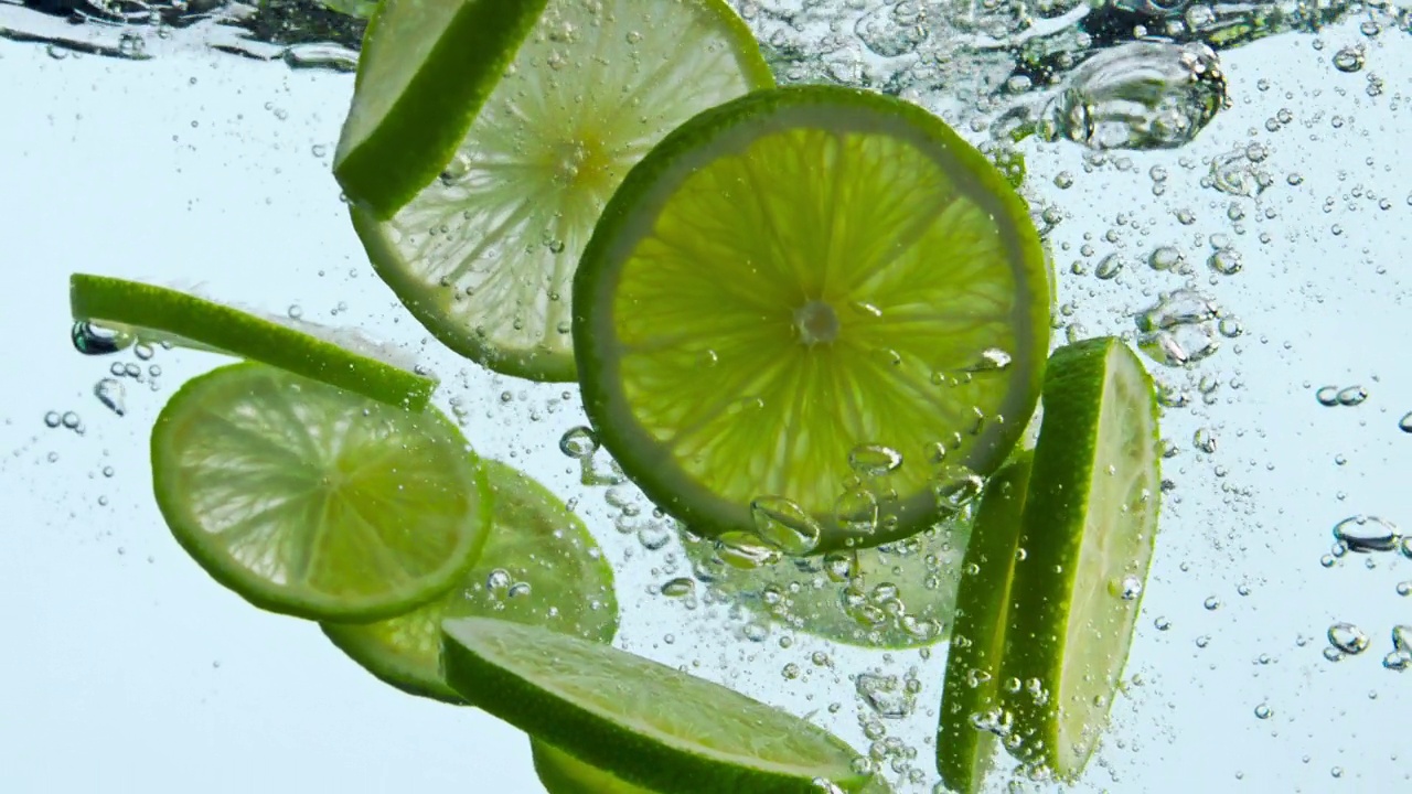 多汁的石灰落水在白色背景。水下漂浮的柑橘特写。视频素材