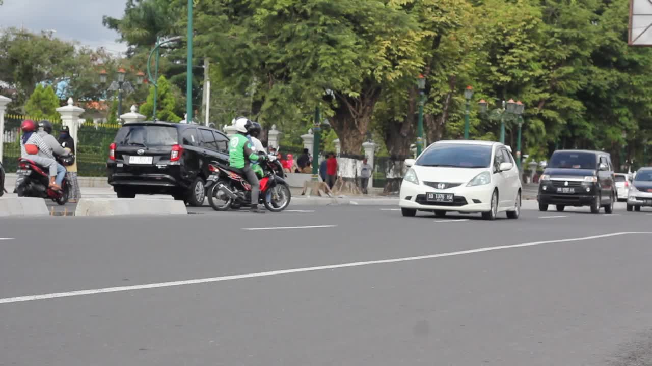 日惹马里奥博罗多车街道。分别是摩托车、汽车、三轮车和行人。视频素材