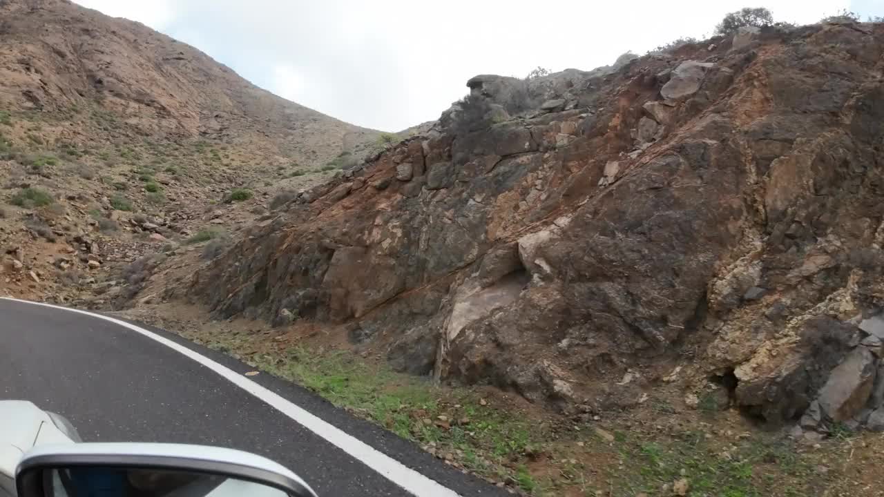 汽车在山路上经过巨大的岩层，火山岩视频素材