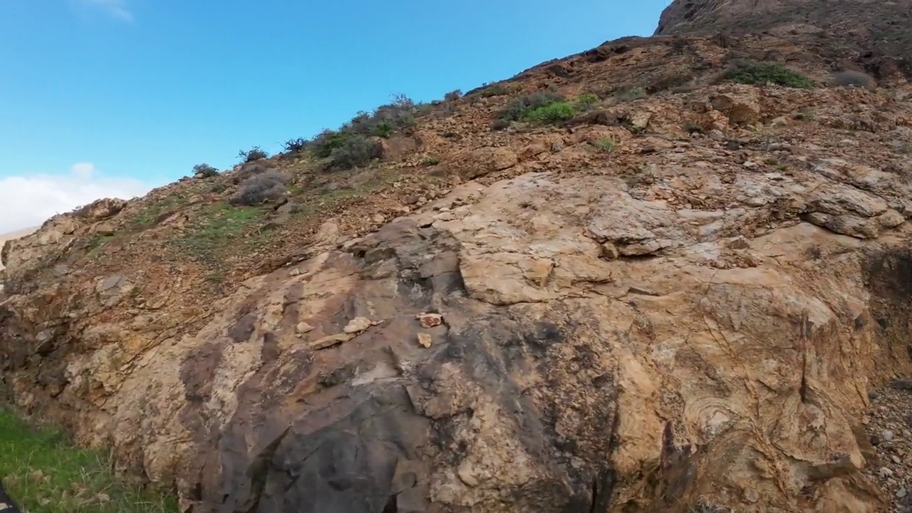 汽车在山路上经过巨大的岩层，火山岩视频素材