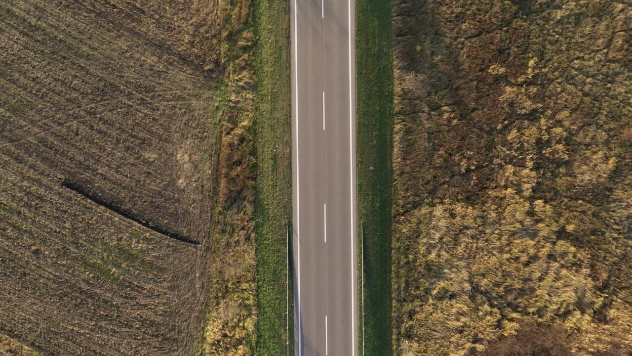 航拍的道路上的交通通过乡村景观，装载工业垃圾卡车后面跟着许多汽车视频素材