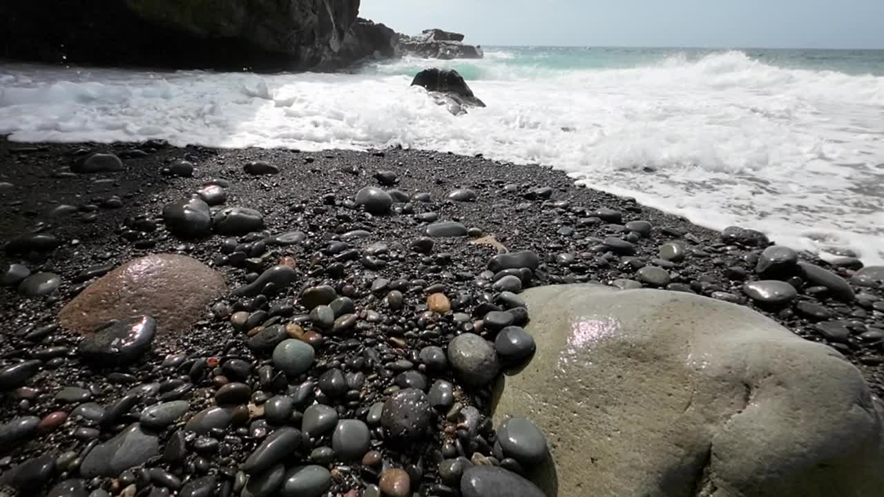 海浪以慢动作冲刷着火山海滩视频素材