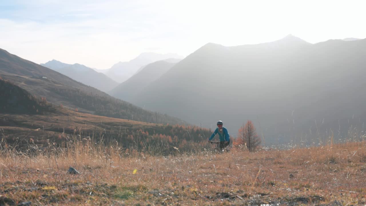 女山地电动自行车手穿越山地草地视频素材