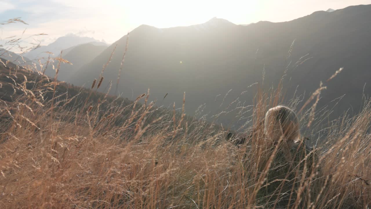 成熟的女性徒步旅行者在脊顶草地上放松视频素材