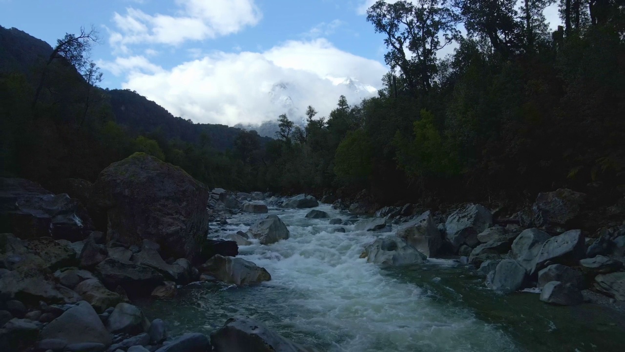 Close up dolly out of the Rio Blanco with snow-capped mountains in the background in Hornopiren National Park, Hualaihué, Chile.视频素材