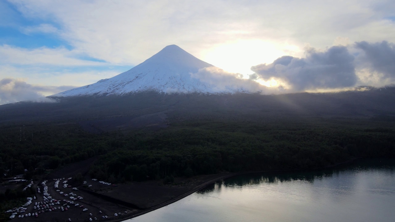 多利鸟瞰托多斯·洛斯·桑托斯湖畔的奥索尔诺火山。火山背后的太阳视频素材