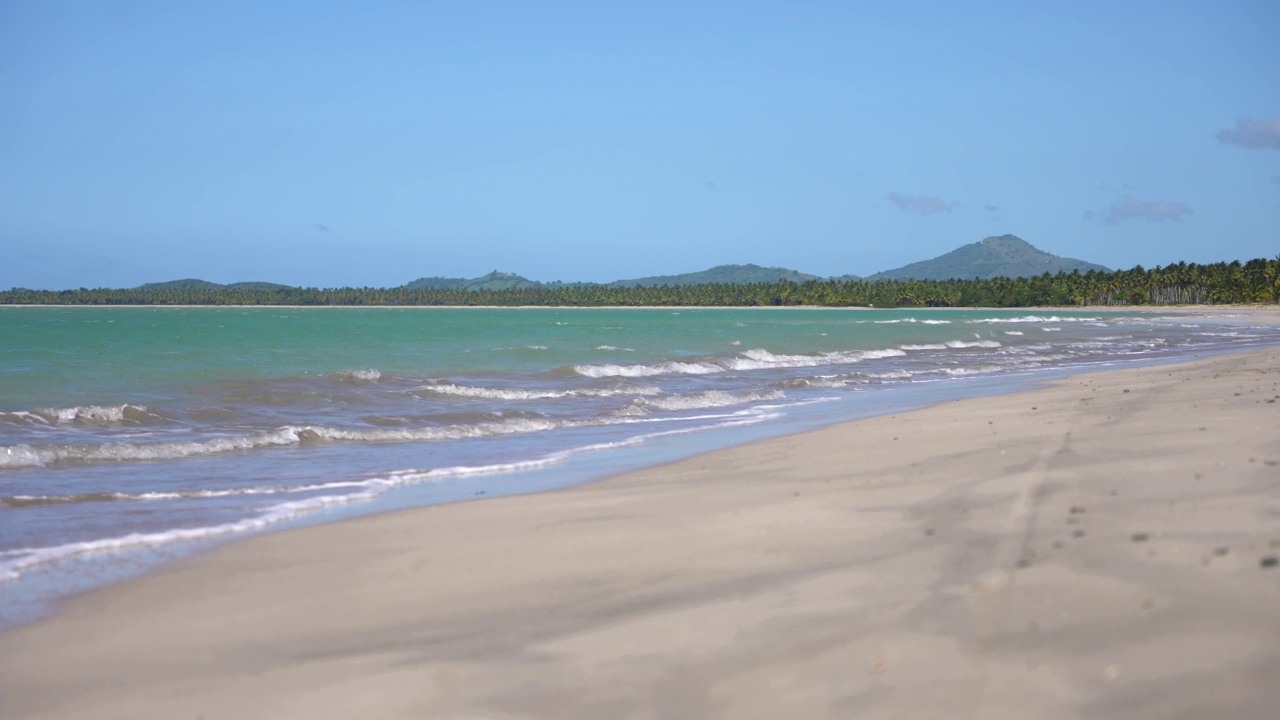 令人惊叹的海景，一个空的热带海滩与蓝绿色的大海和海浪冲击海岸。平静放松的气氛视频素材