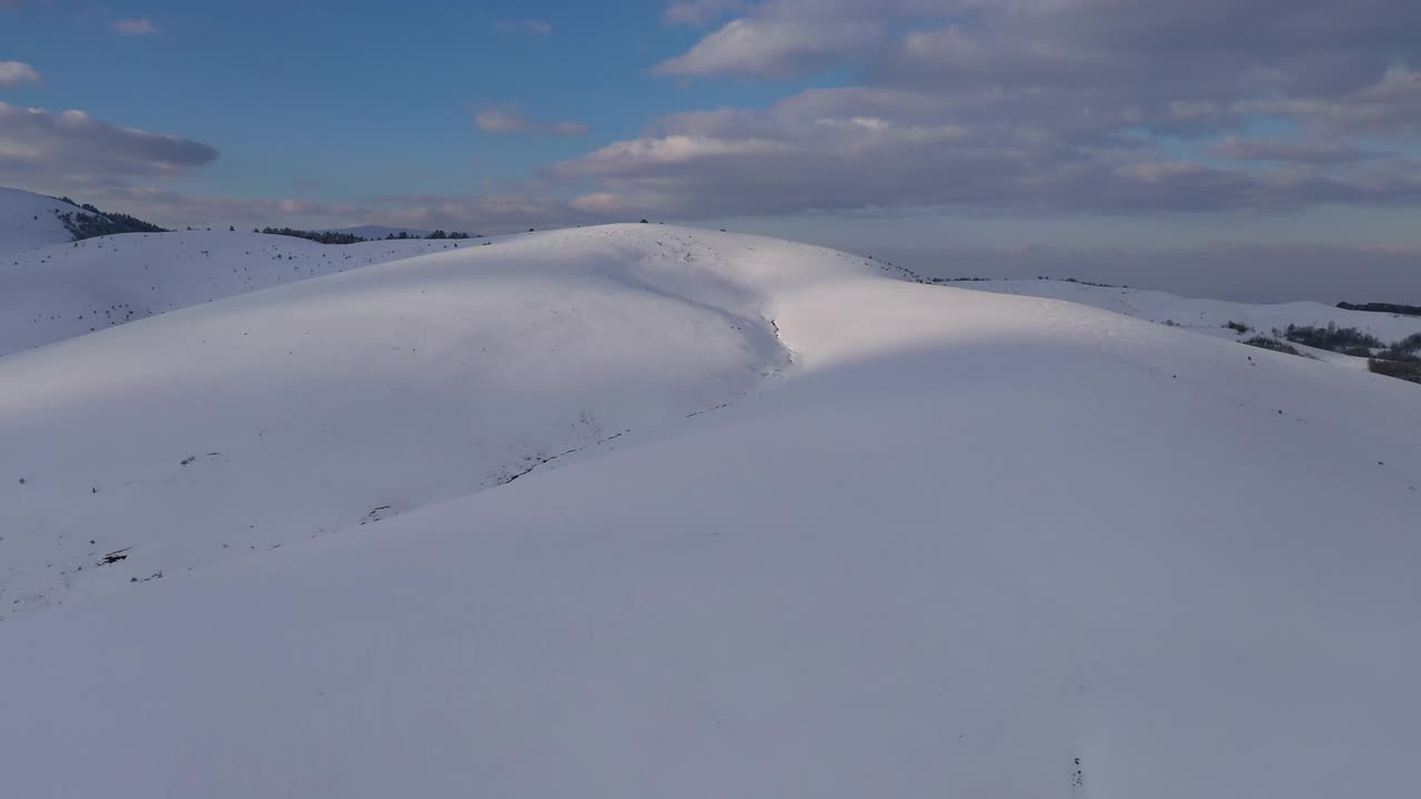 塞尔维亚兹拉蒂博，白雪覆盖的山顶被夕阳照亮。空中射击。视频素材