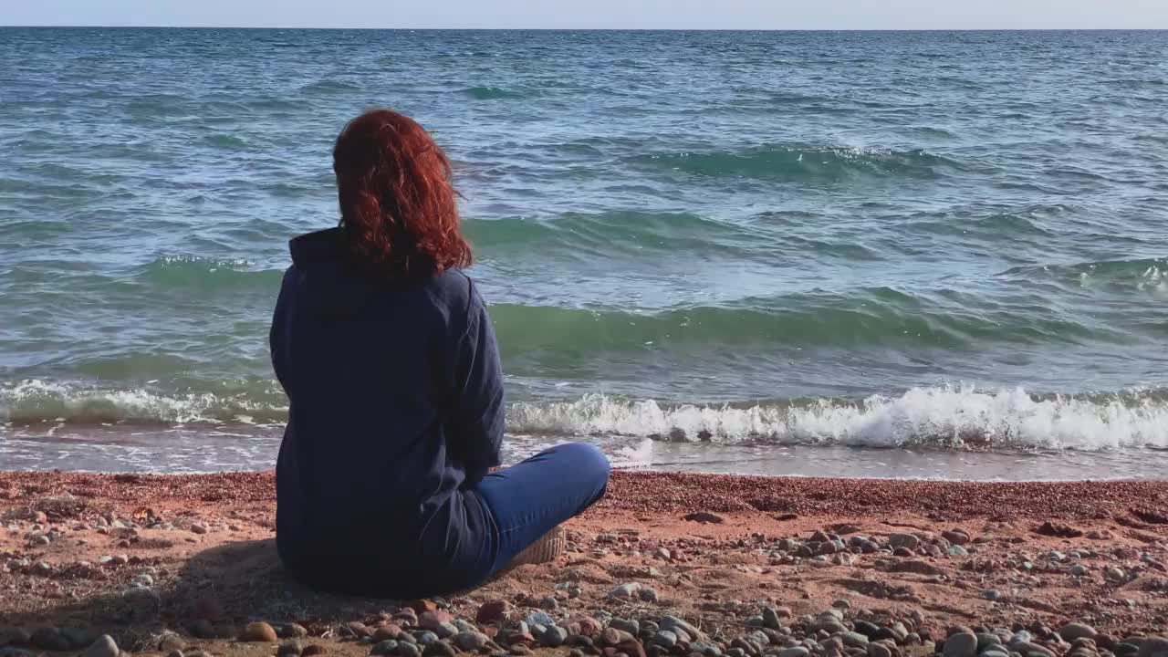 阳光明媚的海岸上的女士视频素材