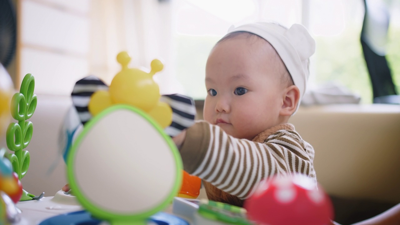 画像可爱的小可爱的亚洲婴儿婴儿幼童坐在客厅玩五颜六色的玩具与乐趣在家里，生活方式学习创造性发展教育儿童的概念视频素材画面3