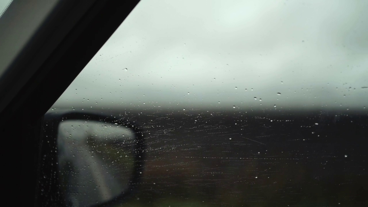 雨点打在车窗玻璃上。阴雨天，坏天气的概念。特写，4k镜头。软聚焦镜头。视频素材