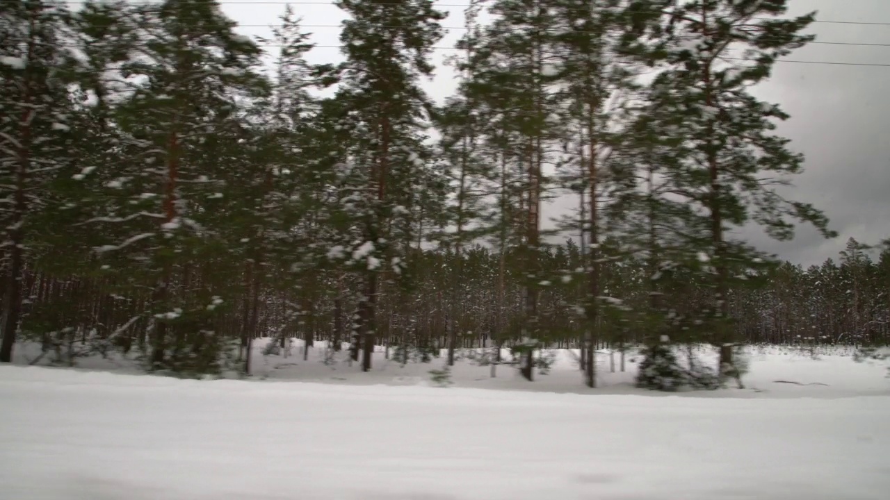 在森林里被雪覆盖的滑溜溜的路上小心驾驶。冬天在空旷的小路上行驶的汽车。视频素材