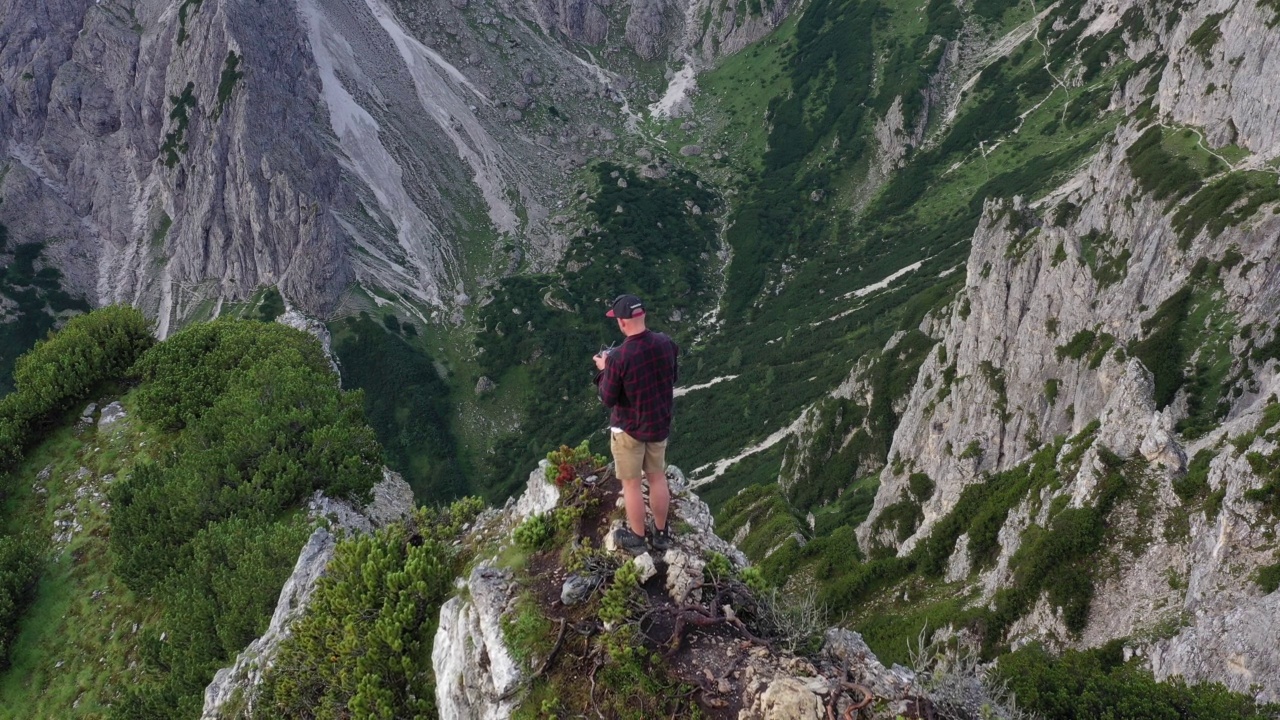 一个人站在一个被落基山脉包围的乡村山顶上的航拍镜头视频素材