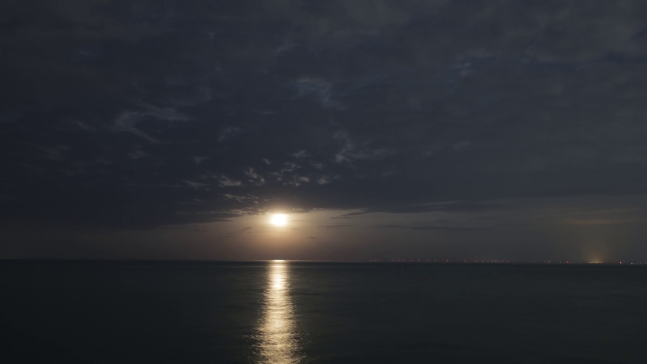 在日出时，云团漂浮在平静的海面上的延时镜头。视频素材