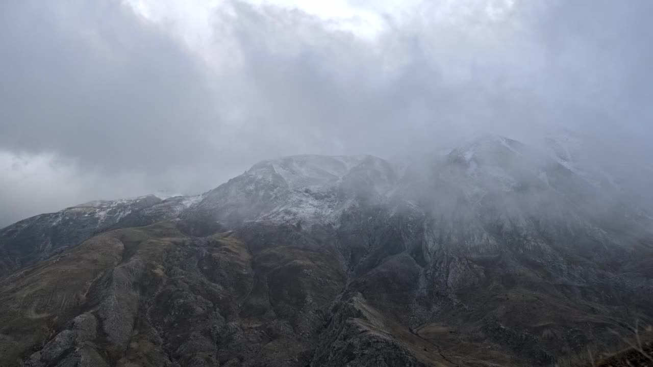 雾和云在雪山前面和上面经过的快速运动视图。视频素材