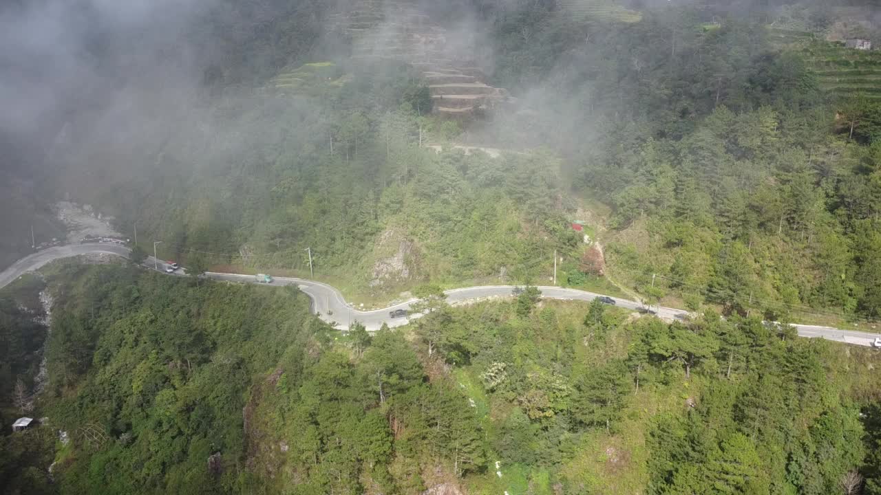 空中移动无人机拍摄的峡谷上方的弯曲道路上停满了汽车视频素材