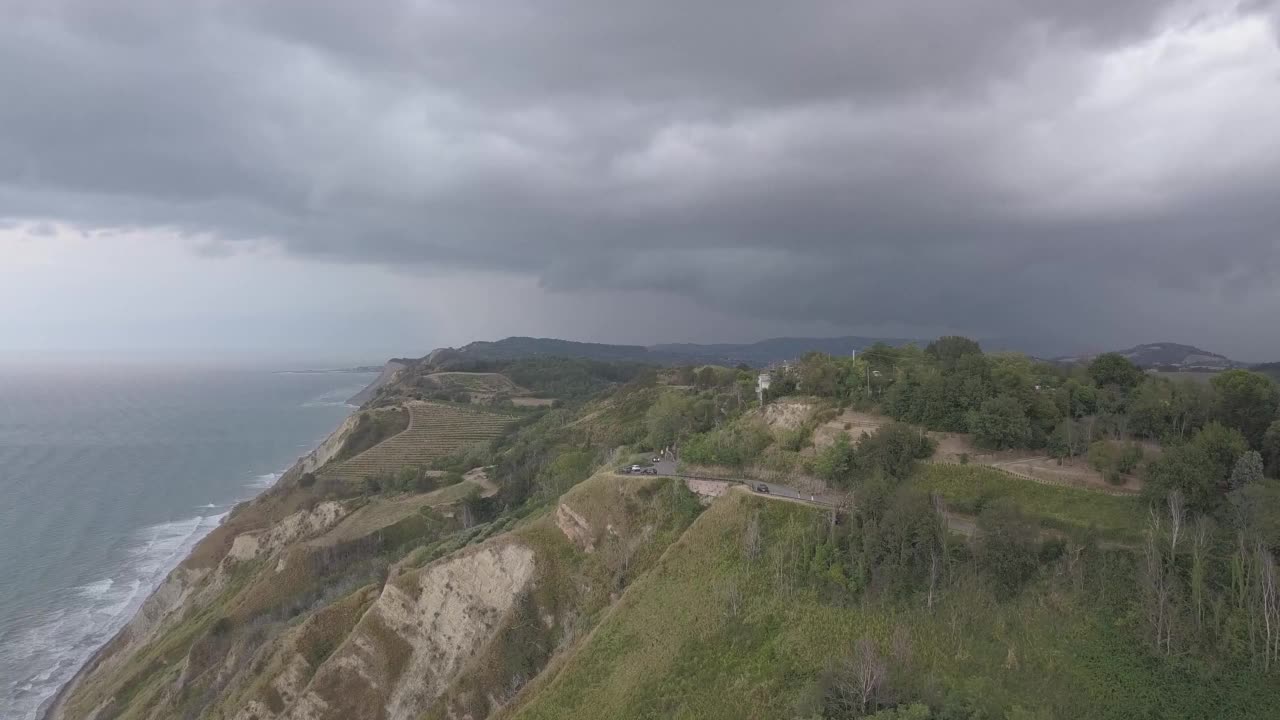 鸟瞰海滩和山脉，高速公路和茂密的绿色树木在多云的天空下视频素材