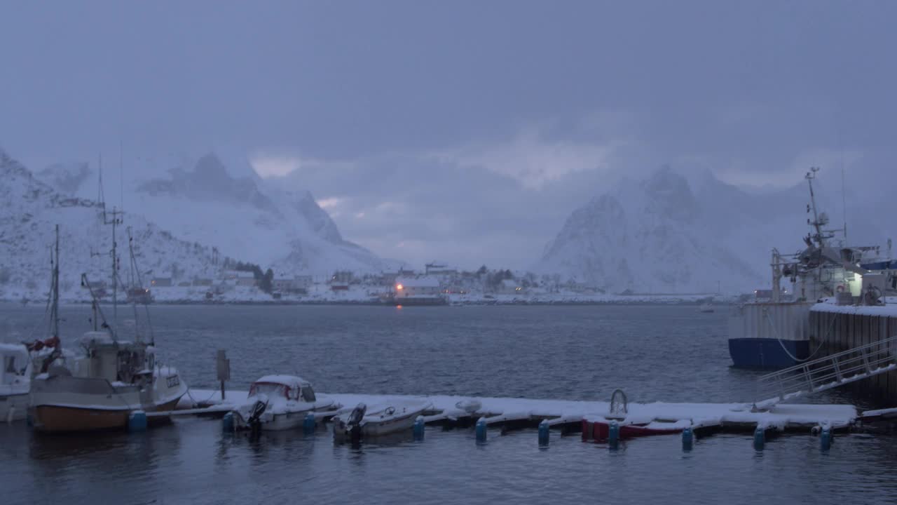 从早到晚，一个港口在白雪覆盖的美丽高山之间的时间流逝视频素材