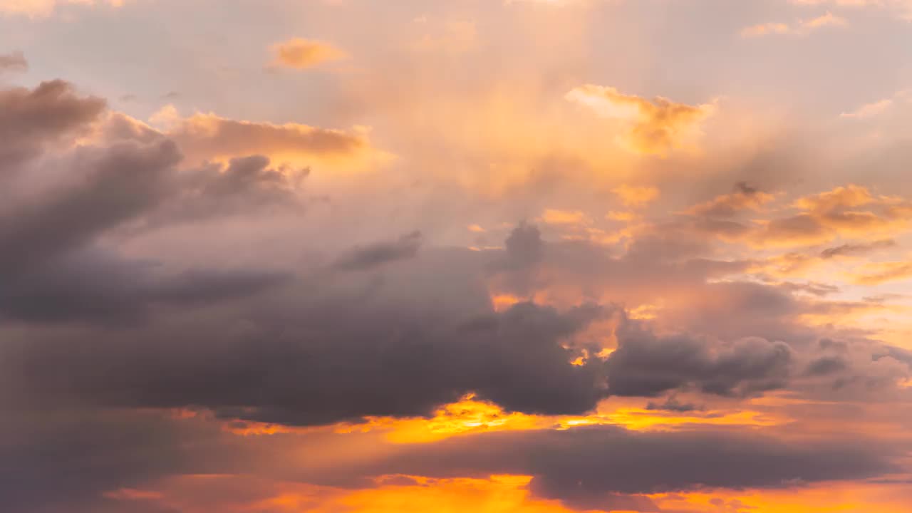 日落多云的天空和蓬松的云。日落天空自然背景。阳光，阳光，阳光，戏剧性的天空。黄色，橙色，粉色的日落。多云的天空和蓬松的云。自然背景，4K，时间推移，时间推移，时间推移视频素材