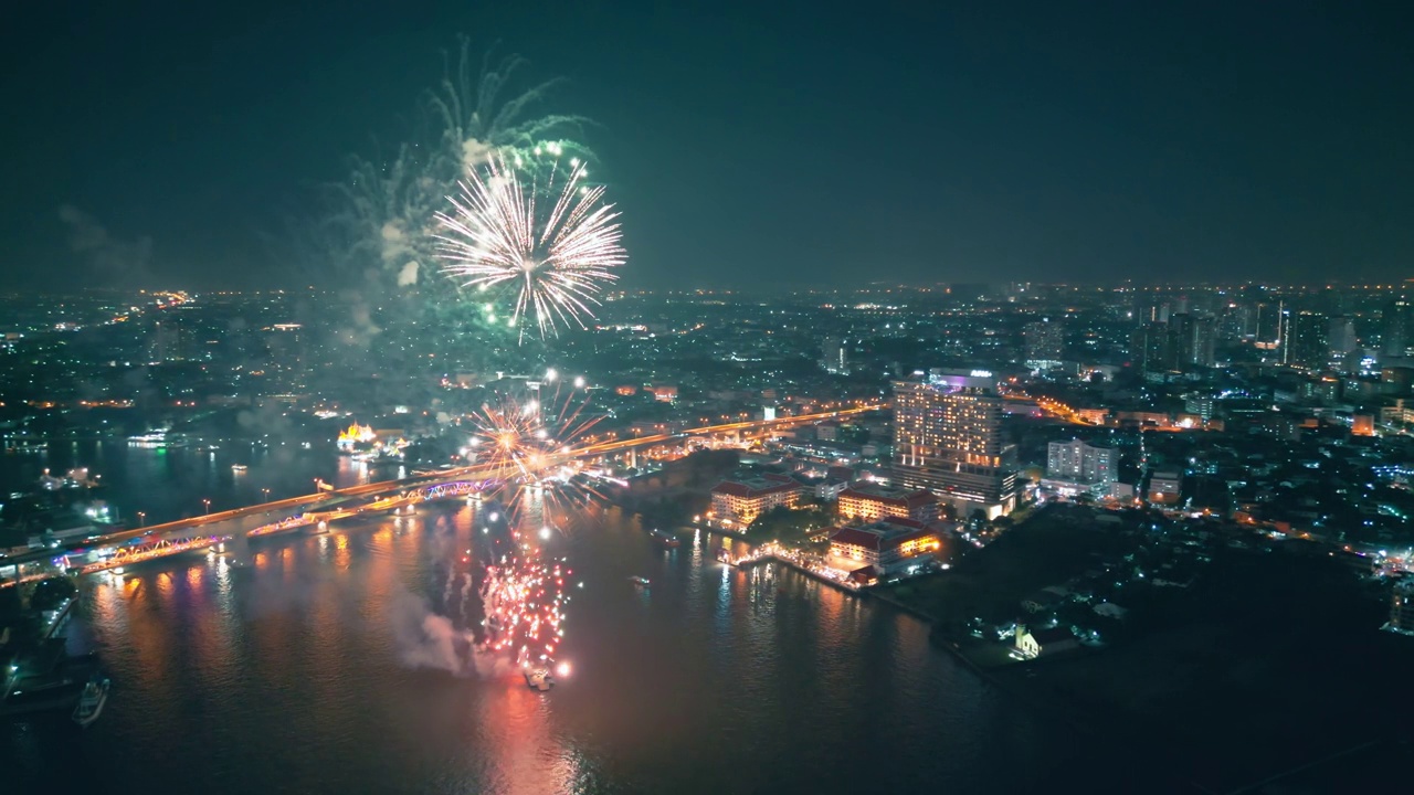 空中无人机视角多色烟花表演在天空之城。除夕。摩天大楼和城市景观庆祝夜晚的灯光视频素材