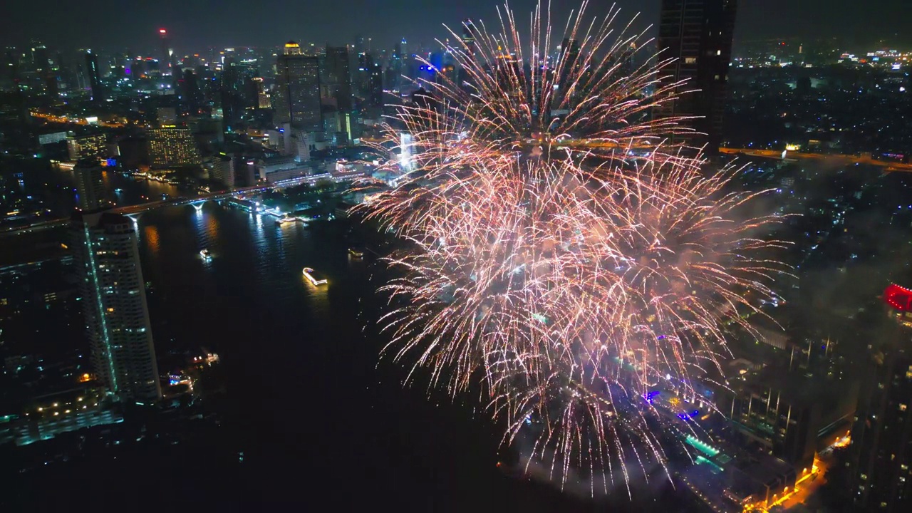 空中无人机视角多色烟花表演在天空之城。除夕。摩天大楼和城市景观庆祝夜晚的灯光视频素材