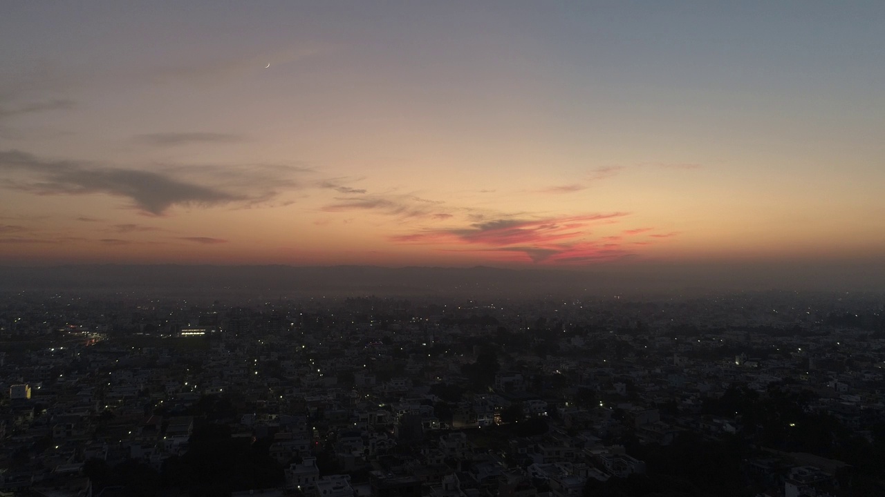 无人机拍摄的居民区日落时五彩缤纷的黄昏天空视频素材