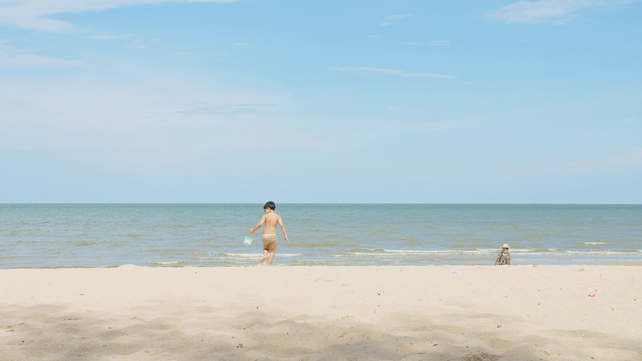 活跃快乐可爱的亚洲儿童男孩享受休闲暑假假期旅行在热带海洋海滩上散步，在阳光明媚的日子蓝天背景下玩沙视频素材