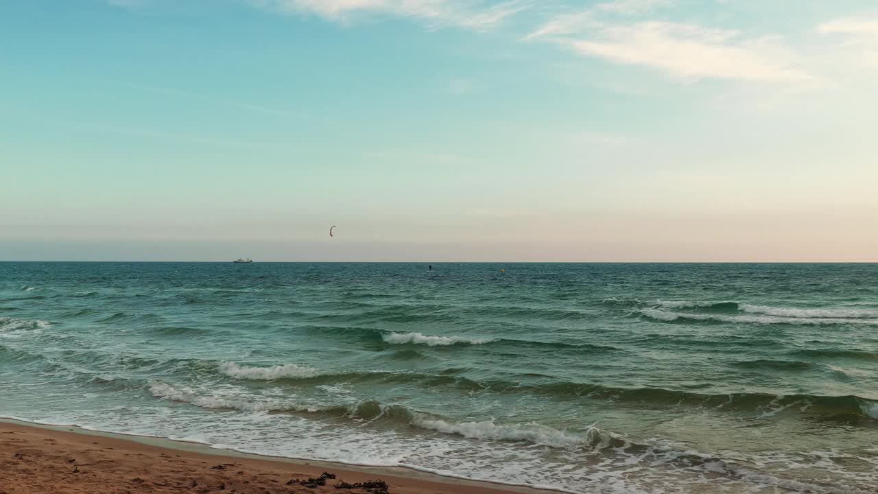 充满活力的海景，大海浪和沙滩。人们在海浪上风筝冲浪视频素材