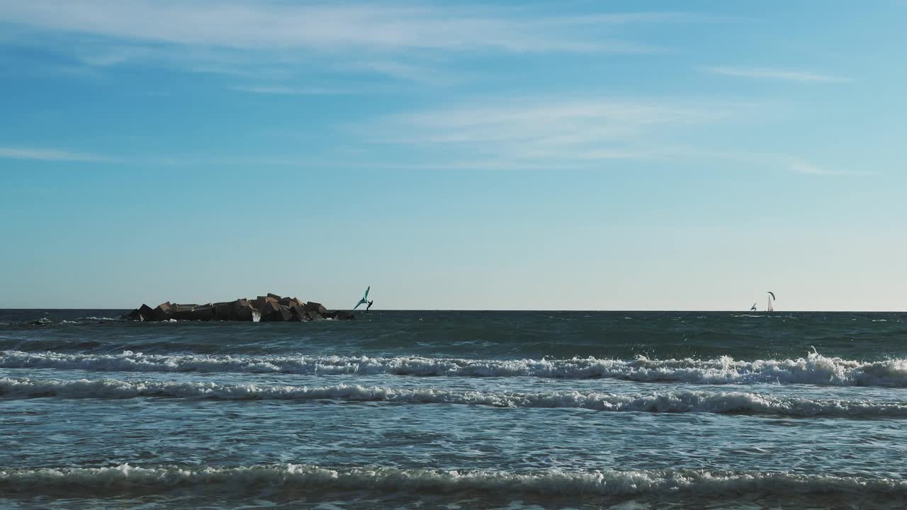 人们在大风天在巨浪上冲浪。年轻活跃人士风筝冲浪视频素材