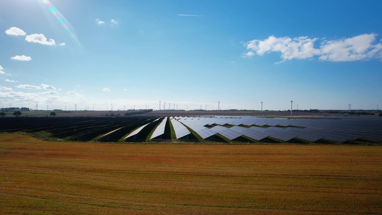 在晴朗的晴天飞往大型太阳能农场的空中飞行。远景视频素材