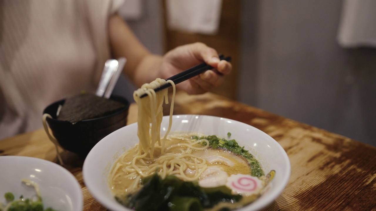 手用筷子挑热汤拉面与味增汤面日式风格视频素材