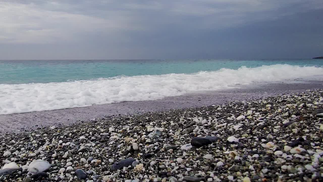 夏季冒险全景在天堂岛的海滩上，靠近蓝色的大海，背景是靠近海浪的黑暗暴风雨的天空视频素材