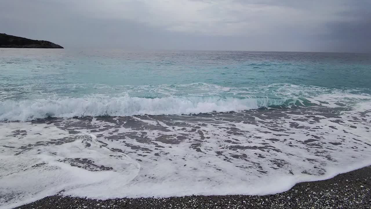 夏季冒险全景在天堂岛的海滩上，靠近蓝色的大海，背景是靠近海浪的黑暗暴风雨的天空视频素材