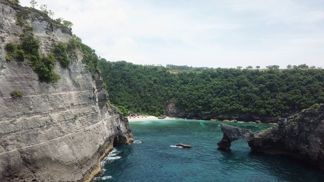 缓慢的悬崖边空中飞行到巴厘的Batupadasan Atuh海滩视频素材