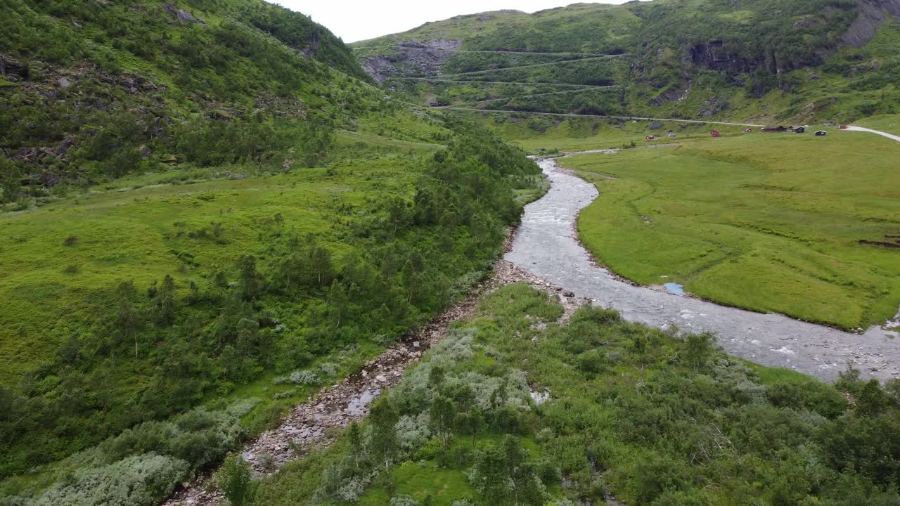 田园诗般的Myrkdalen河在Vikafjell挪威与Halsabakkane蜿蜒圆雕刻成山的背景-空中视频素材