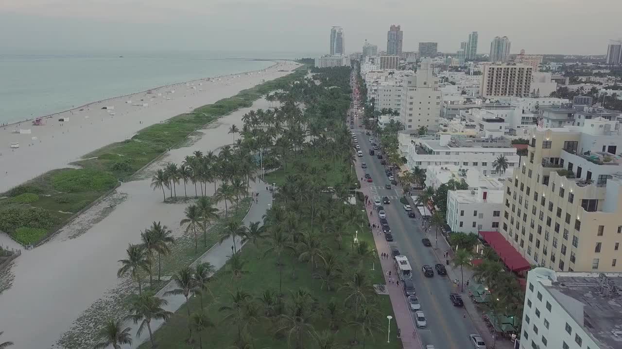 航拍的汽车在公路上被建筑物包围在海边的高清视频素材