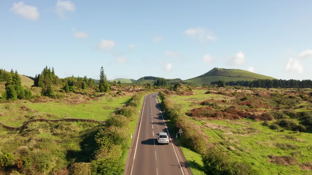 航拍汽车行驶在青山和田野之间的高速公路上视频素材