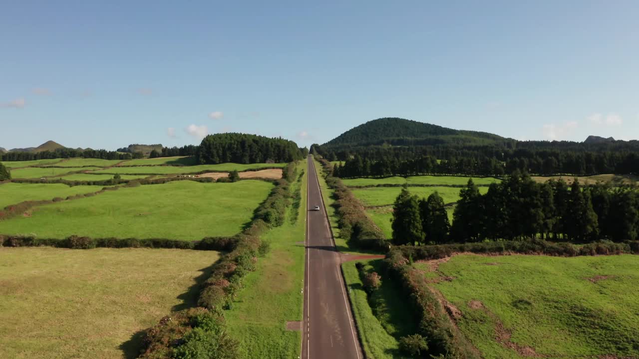 航拍汽车行驶在青山和田野之间的高速公路上视频素材