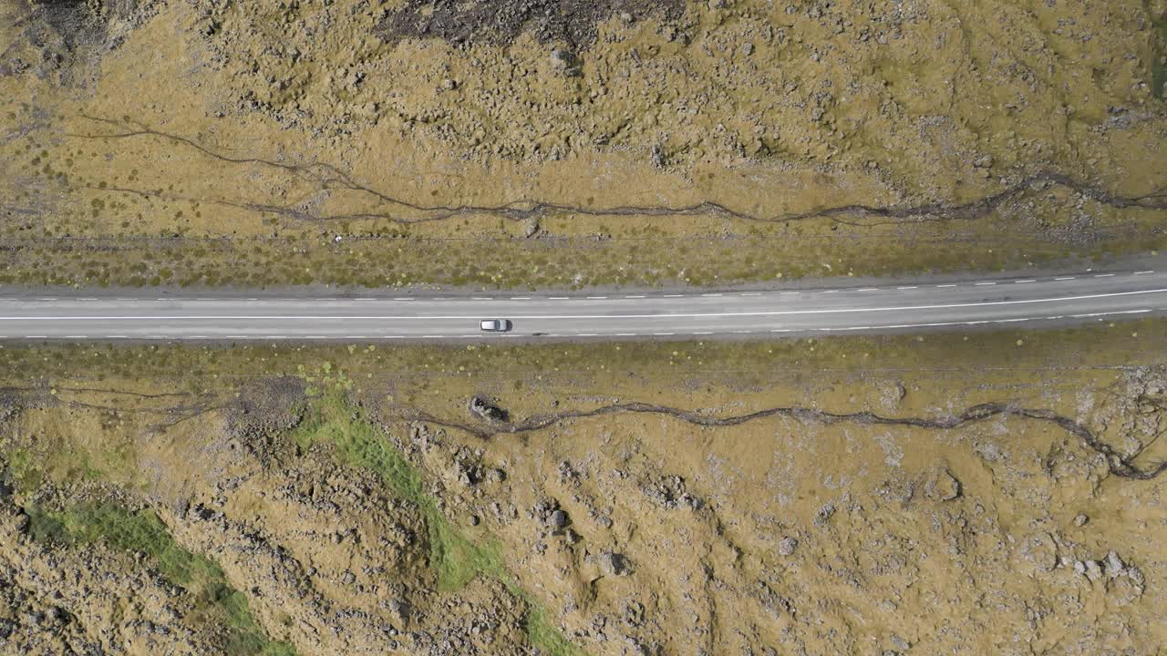 汽车在冰岛落基山脉的沥青道路上行驶的俯视图。无人机航拍视频素材