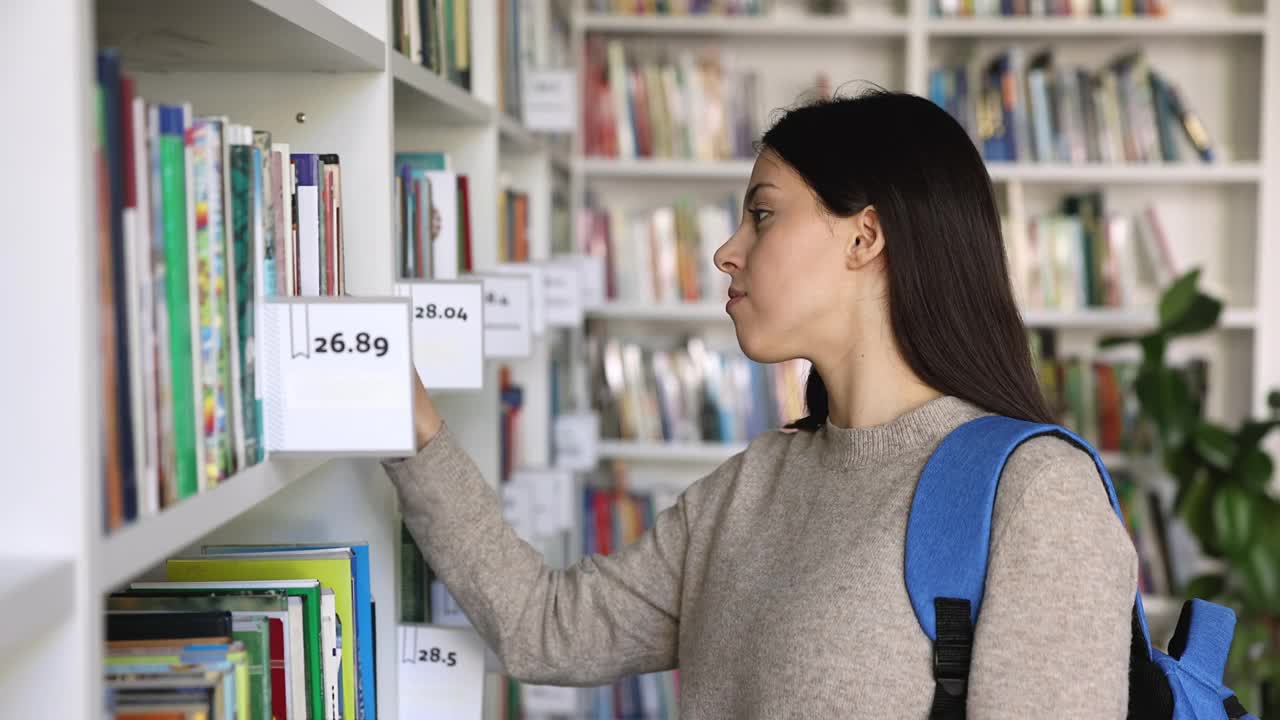 女学生在大学图书馆找书视频素材