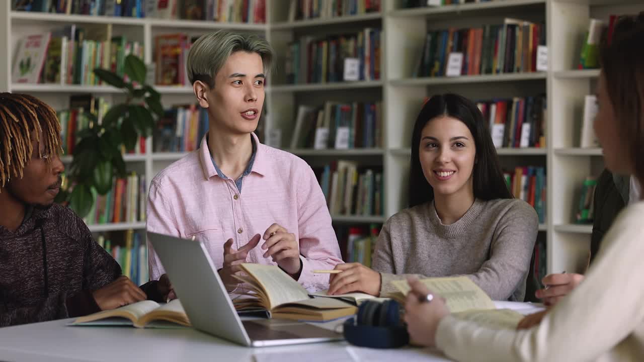 友好的多国同学坐在图书馆一起学习视频素材