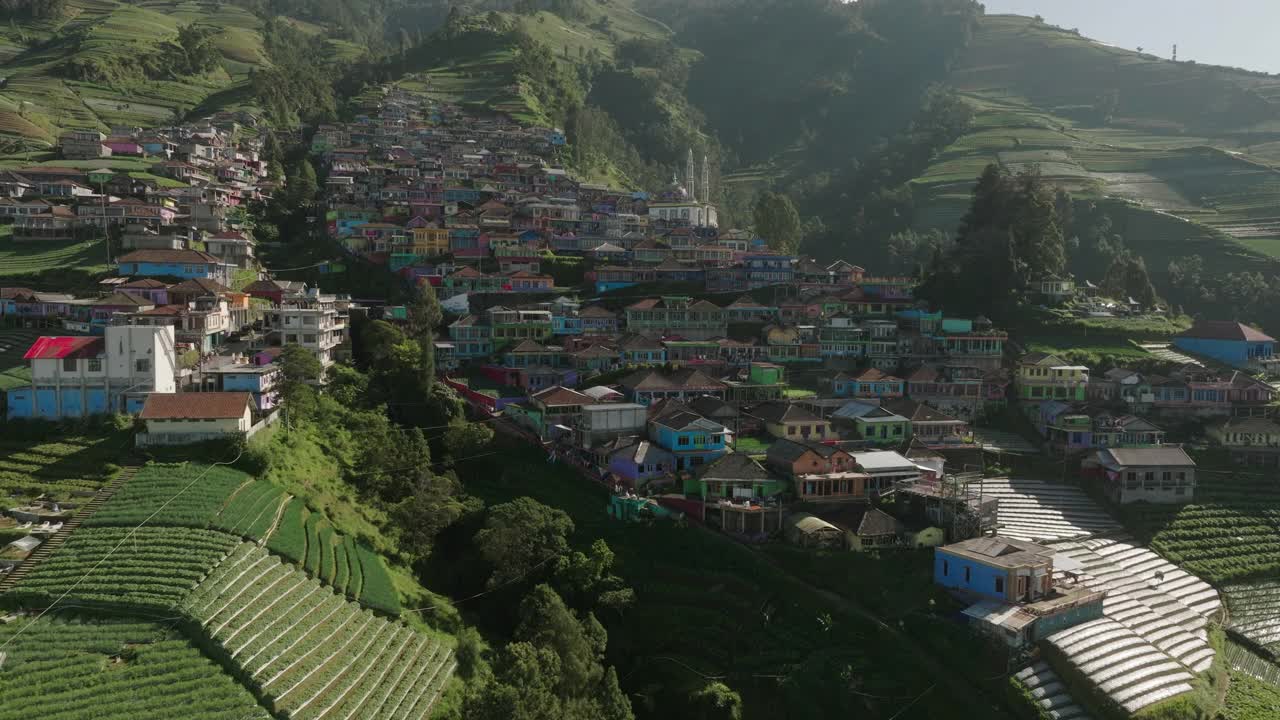 空中平移拍摄的清真寺拜图塔瓦布图在迷你村庄，无人机在阳光明媚的日子飞过房屋-爪哇，印度尼西亚视频素材