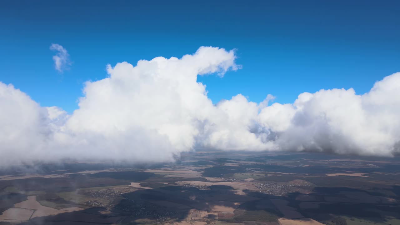 从高空飞机窗口鸟瞰暴雨前形成的浮肿积云所覆盖的地面视频素材