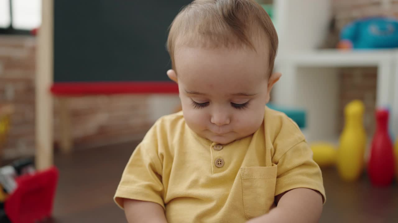 可爱的西班牙宝宝坐在幼儿园地板上玩积木视频素材