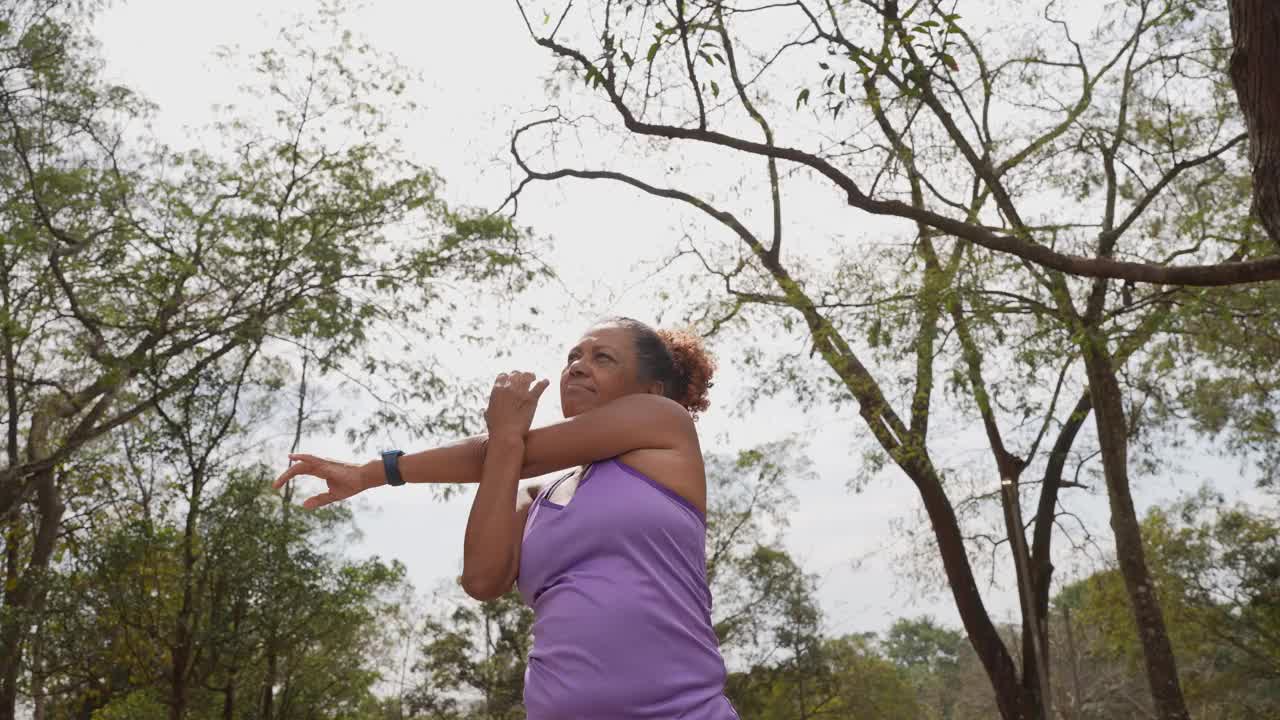 一位老年妇女在公园里伸展身体视频素材