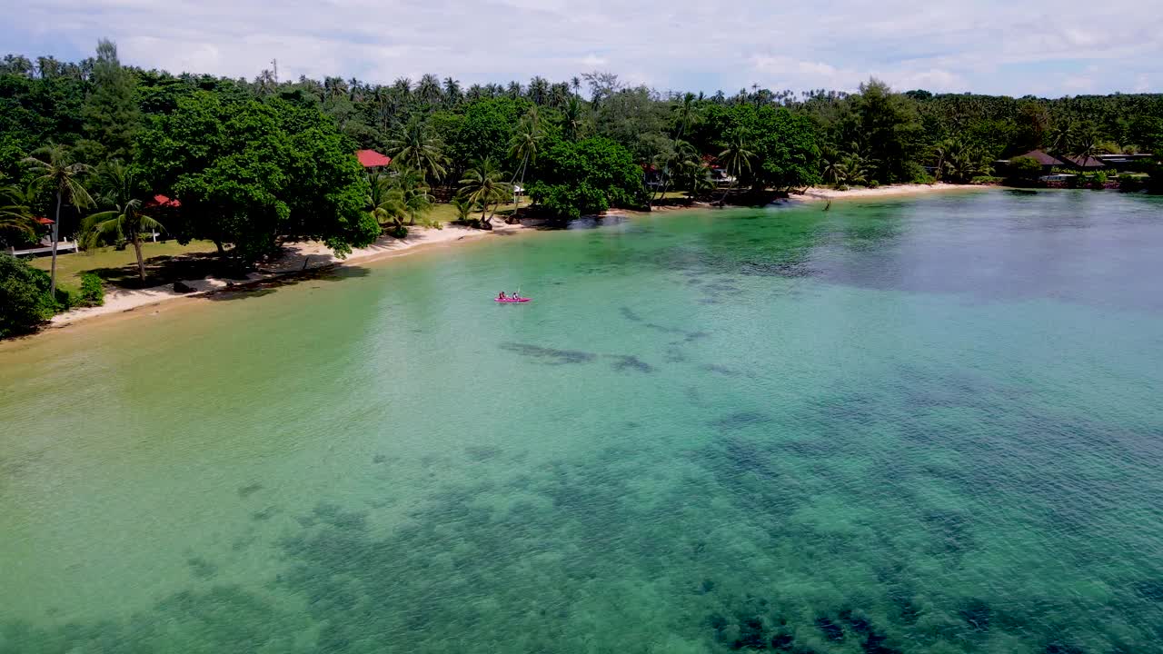 在泰国的一个热带岛屿上，一对夫妇划着皮艇，绿蓝turqouse色的Koh Mak海洋视频素材