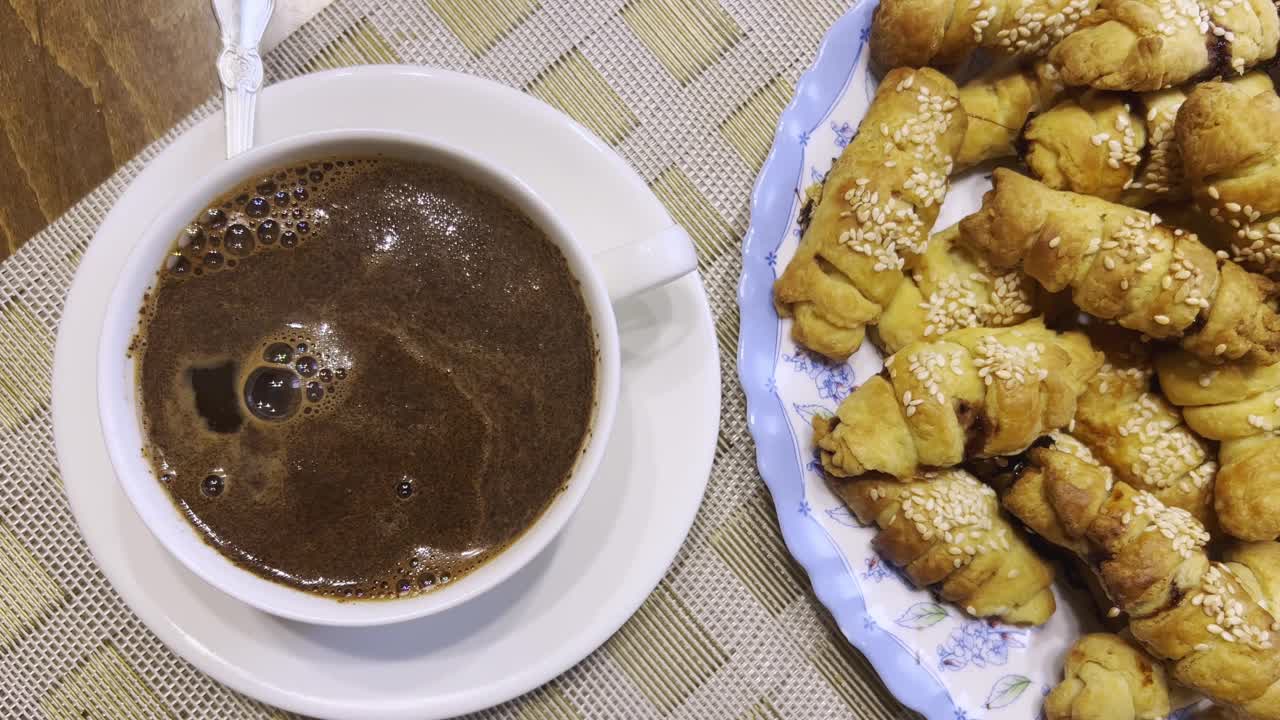 俯视图一杯咖啡和美味的自制饼干与芝麻附近。视频素材